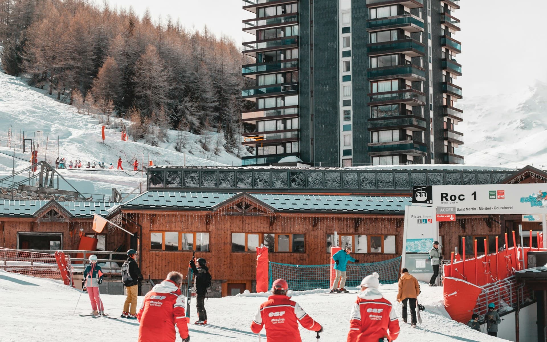 Des groupes de skieurs se rassemblent avec leurs moniteurs au pied des pistes
