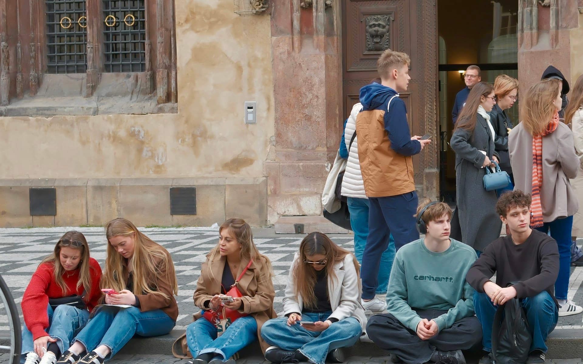 Groupe de jeunes voyageurs faisant une pause dans le centre historique de Prague