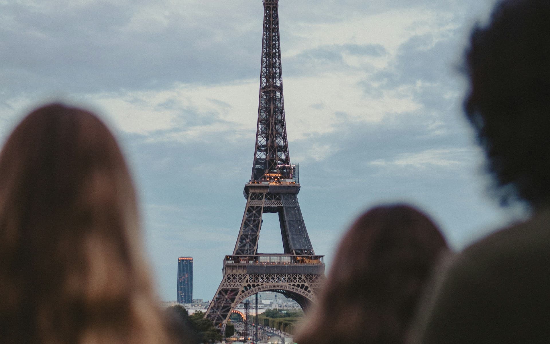 Groupe de visiteurs observant la tour Eiffel depuis une rue de Paris