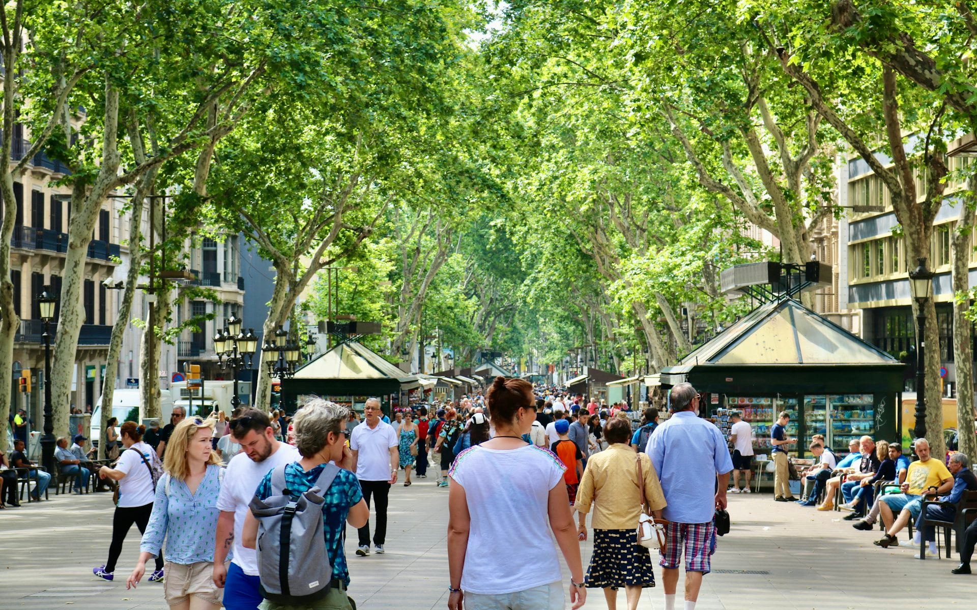 Des voyageurs marchent sur les Ramblas arborées à Barcelone